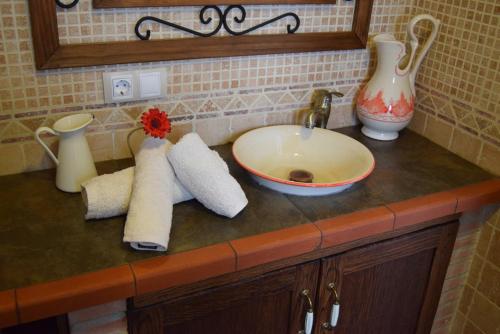 encimera con fregadero, jarrón y toallas en Casa Rosario en Cartajima