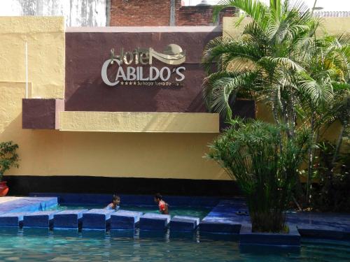 two people swimming in a swimming pool at a hotel at Hotel Cabildos in Tapachula