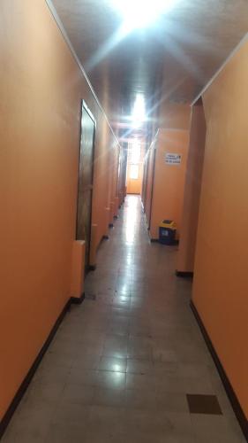 a long hallway with a light at the end of a building at Hotel Latino in San José