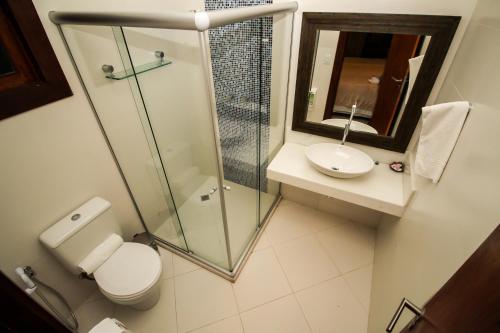 a bathroom with a shower and a toilet and a sink at Pousada João Sol in Praia do Forte