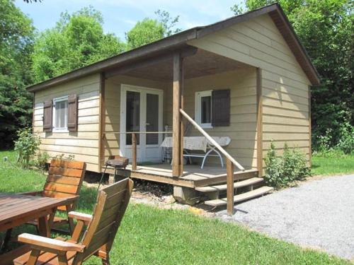 a small cabin with a porch and a picnic table at Chalet Des Menhirs in Moulin-Mage