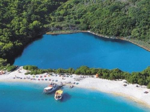 two boats are docked on the shore of a beach at Apartment Zeus with private pool and sea view in Nisakion