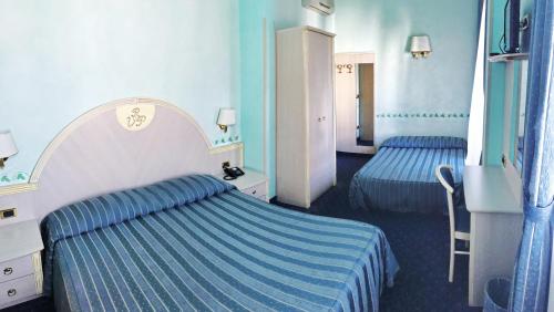 ピサにあるB&B Villa Primaveraの青い壁のホテルルーム(ベッド2台付)