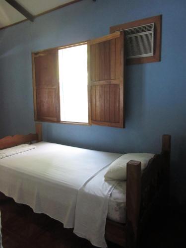 a bedroom with a white bed and a window at Caballito's Mar in Ometepe