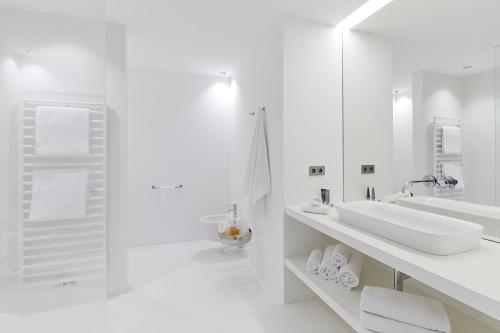 a white bathroom with a sink and a mirror at The View Luxury Suites in Lagundo