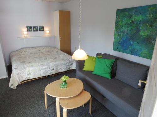 ブラーバンドにあるMotel Garni Blåvandのベッドルーム1室(ベッド1台、ソファ、テーブル付)
