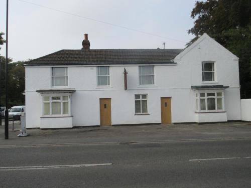 a white house with two doors on a street at Anchor House 2 East Street Alford Lincolnshire LN13 9EQ in Alford