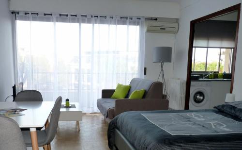 a living room with a bed and a couch at Appartement Perpignan Centre Place Catalogne in Perpignan