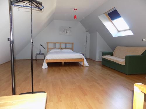 1 dormitorio en el ático con 1 cama y 1 sofá en Maisonette La Quiétude, en Wimereux