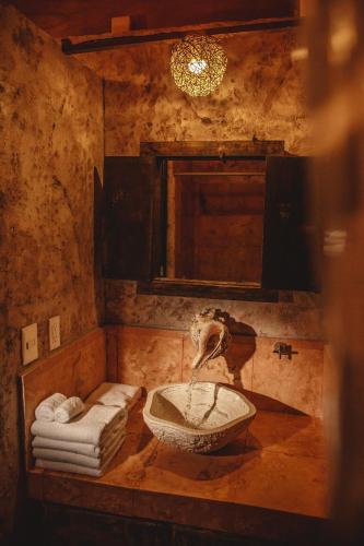 a bathroom with a sink and a mirror and towels at Serenity Authentic Glamping Tulum in Xpu Ha