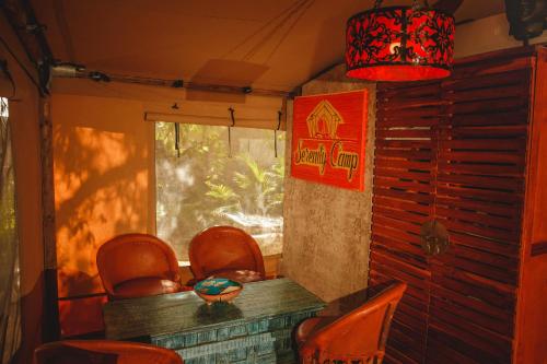 a room with chairs and a table and a window at Serenity Authentic Glamping Tulum in Xpu Ha