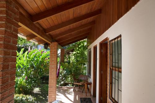 a patio with a wooden roof and a table and chairs at Escape Caribeño in Puerto Viejo