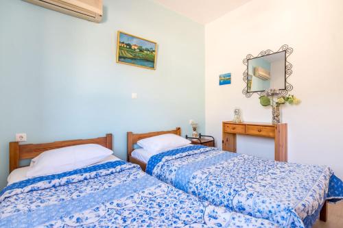 a bedroom with two beds and a mirror at Maria's House in Katelios