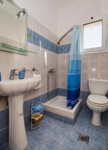 a bathroom with a sink and a toilet and a shower at Maria's House in Katelios