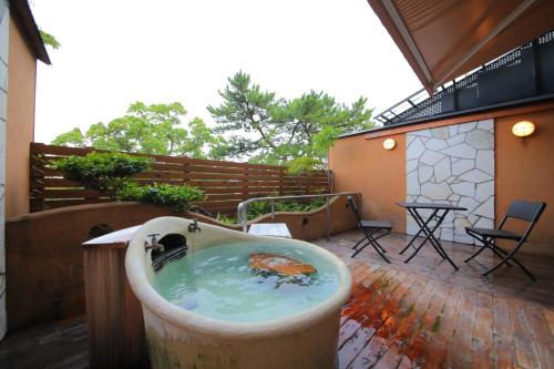 a bird bath on a patio with a table and chairs at Hotel Beppu Pastoral in Beppu