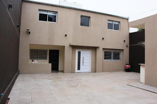 a house with a white door and a driveway at Villa Cabrera Apart and Suites in Córdoba