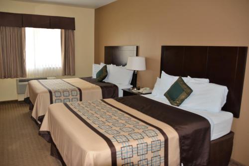 a hotel room with two beds and a window at Irish Inn and Suites in Muleshoe