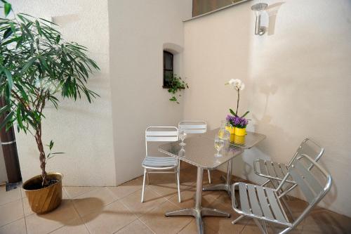 a table and chairs in a room with a plant at Hotel Petr in Prague
