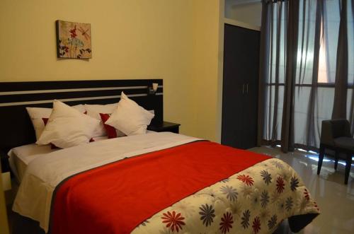 a bedroom with a large bed with a red blanket at Country Hotel in Chimbote