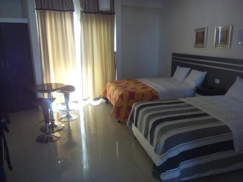 a hotel room with two beds and a table at Country Hotel in Chimbote