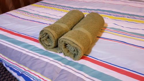 two rolled up towels sitting on top of a bed at Regalia Suites & Residences KLCC Infinity Pool by 109 Global Host in Kuala Lumpur