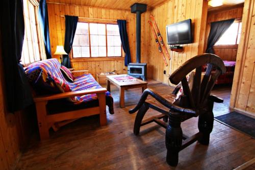 a living room with a couch and a chair and a tv at Three Bears Lodge in Red River