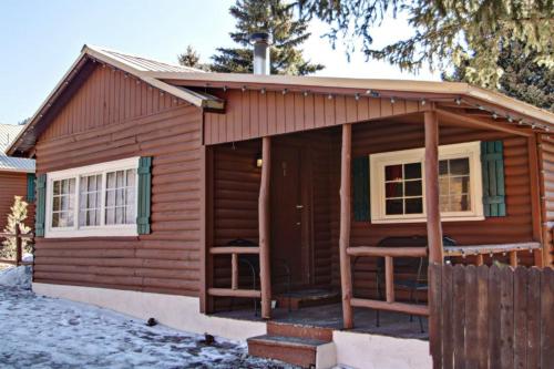 a log cabin with a porch and two windows at Three Bears Lodge in Red River