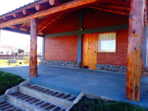 a porch of a house with a wooden door at Cabañas Atrapasueños in Trevelin