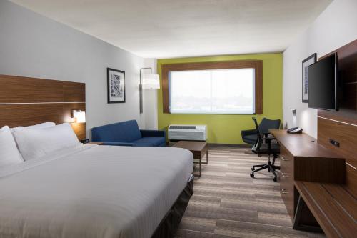 una camera d'albergo con letto, scrivania e TV di Holiday Inn Express Visalia-Sequoia Gateway Area, an IHG Hotel a Visalia