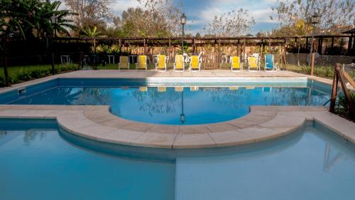 - une piscine avec des chaises et de l'eau bleue dans l'établissement Pro Hotel, à Pilar