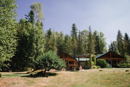 a log cabin in the woods with a yard at Cedar Haven Cabins and Resort in Clearwater
