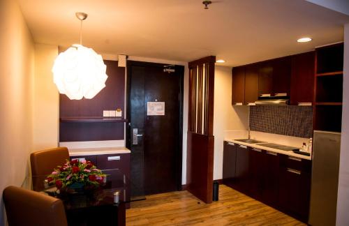 eine Küche mit einem Tisch und einem Esszimmer in der Unterkunft Ming Garden Hotel & Residences in Kota Kinabalu