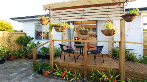a wooden deck with chairs and potted plants at Gumnut Getaway BnB in Goolwa North