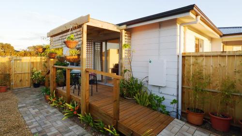 una casa con terraza de madera junto a una valla en Gumnut Getaway BnB en Goolwa North