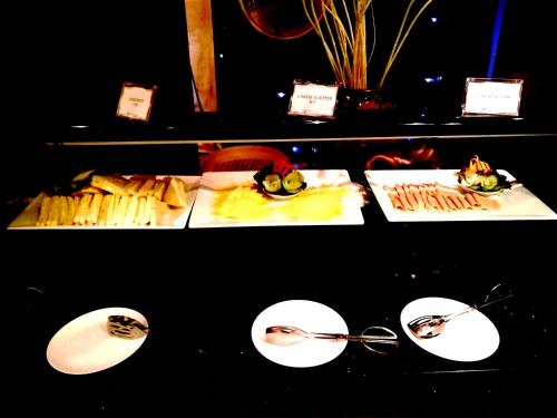 a table with plates of food and spoons at Ming Garden Hotel & Residences in Kota Kinabalu