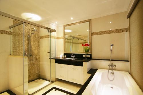 a bathroom with a tub and a sink and a shower at LK Miracle Suite - SHA Extra Plus in Pattaya South