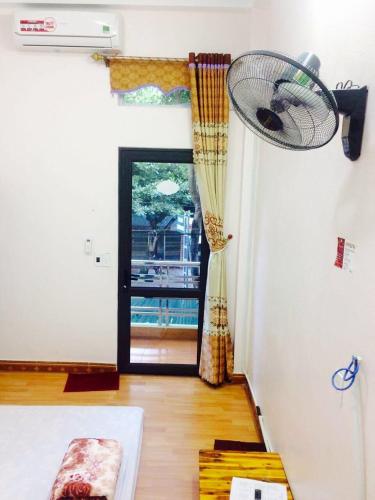 a living room with a fan hanging from the wall at Ngan Ha Homestay in Ha Giang