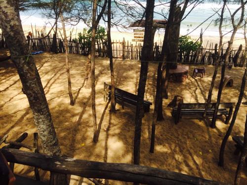 a park with benches and trees in the sand at Beach Hut in Arugam Bay