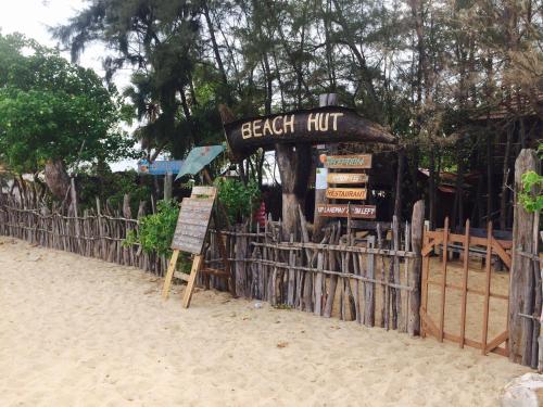 a beach hut with a sign next to a fence at Beach Hut in Arugam Bay