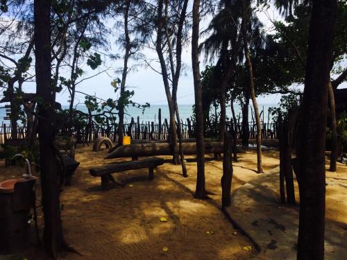 a park with benches and trees and the ocean at Beach Hut in Arugam Bay