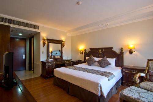 Habitación de hotel con cama grande y espejo en LK Metropole, en Pattaya central