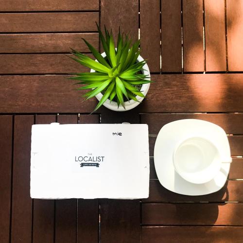 a table topped with a white envelope and a plant at Rumah Kertajaya in Surabaya