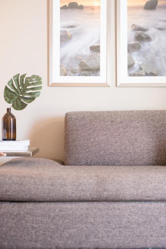 a bedroom with a couch and two pictures on the wall at Novotel Wollongong Northbeach in Wollongong