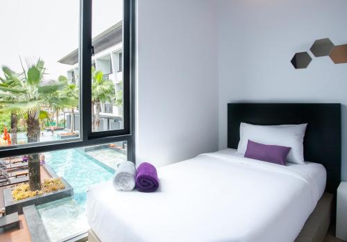 a bedroom with a bed and a large window at Chaweng Villawee Hotel - SHA Plus in Chaweng