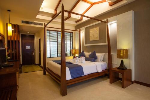 a bedroom with a canopy bed in a room at Access Resort & Villas in Karon Beach