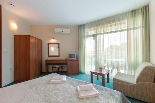 a bedroom with a bed and a desk and a window at Hotel L&B- Free parking in Sunny Beach