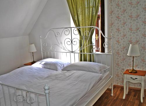 a white bed with a metal headboard in a bedroom at Villa Winter Prestige Apartments in Maribor
