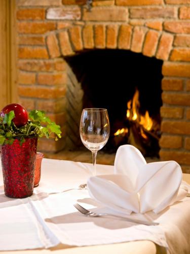 a table with a glass of wine and a fireplace at Der Schwendterwirt in Schwendt
