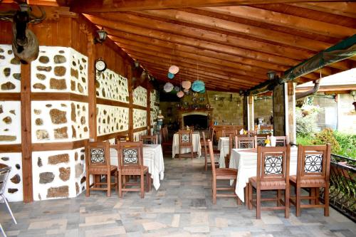 a restaurant with white tables and chairs and a wooden ceiling at Complex Oazis in Etropole