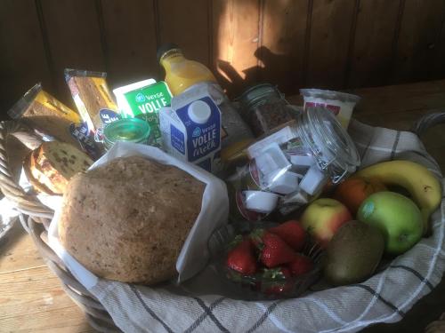 un panier rempli de nourriture et de fruits sur une table dans l'établissement B & Buitenlust, à Schagerbrug